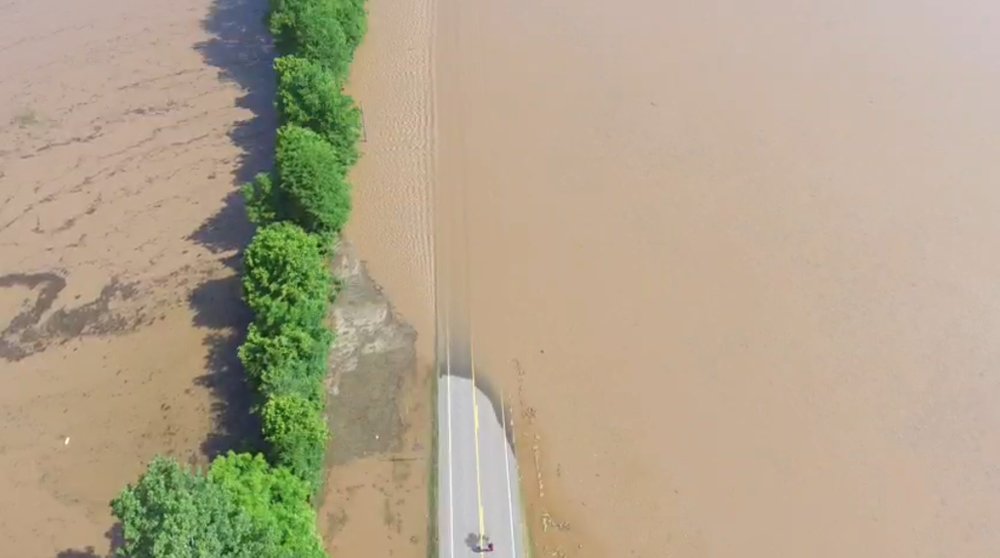 Water covers Arkansas 155 near where water tore through a levee early Friday.