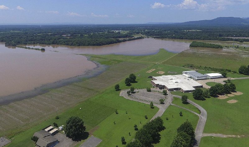 Floodwaters draw close to Dardanelle Middle School on Saturday on the northern side of Arkansas 7. A rupture in the Dardanelle Levee widened overnight Friday, threatening 700 to 800 homes in the city, Dardanelle Mayor Jimmy Witt said Saturday. Crews were building a temporary levee in an attempt to hold back the water. 