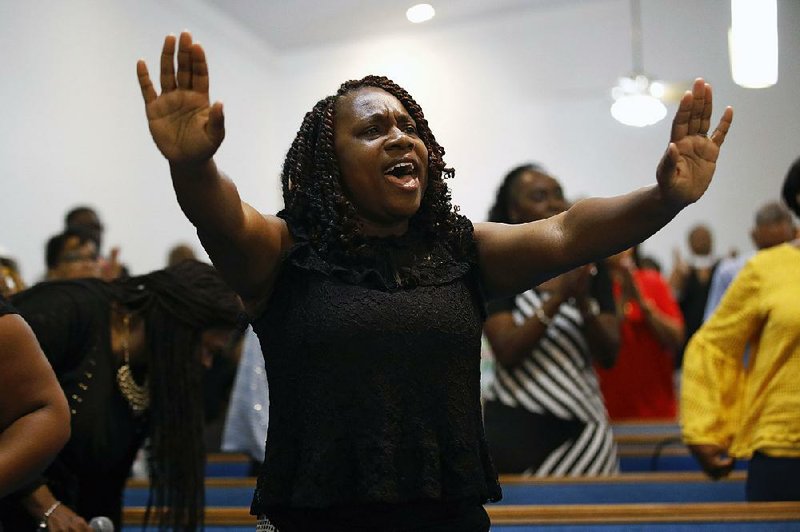 A woman sings Sunday at Piney Grove Baptist Church in Virginia Beach, Va., during a vigil for the victims of last week’s mass shooting at a city government building. story.lead_photo.caption