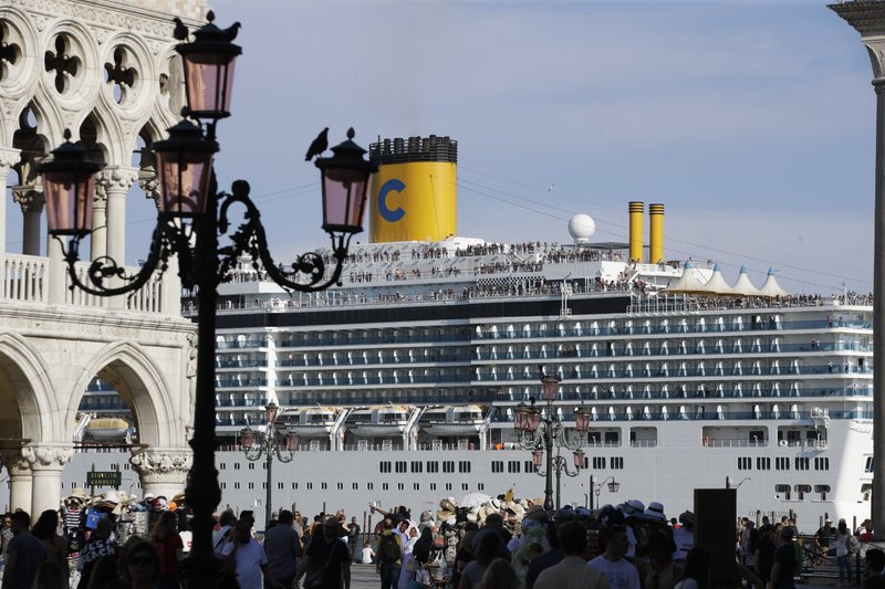 A cruise ship passes by St. Mark's Square filled with tourists, in Venice, Italy, Sunday, June 2, 2019. Groups that want to ban cruise ships on Venice's busy canals say a collision that injured four tourists has served as a wake-up call. Opponents say cruise ships are out-of-scale for Venice, cause pollution, threaten the lagoon's ecosystem and dangerous. (AP Photo/Luca Bruno) story.lead_photo.caption