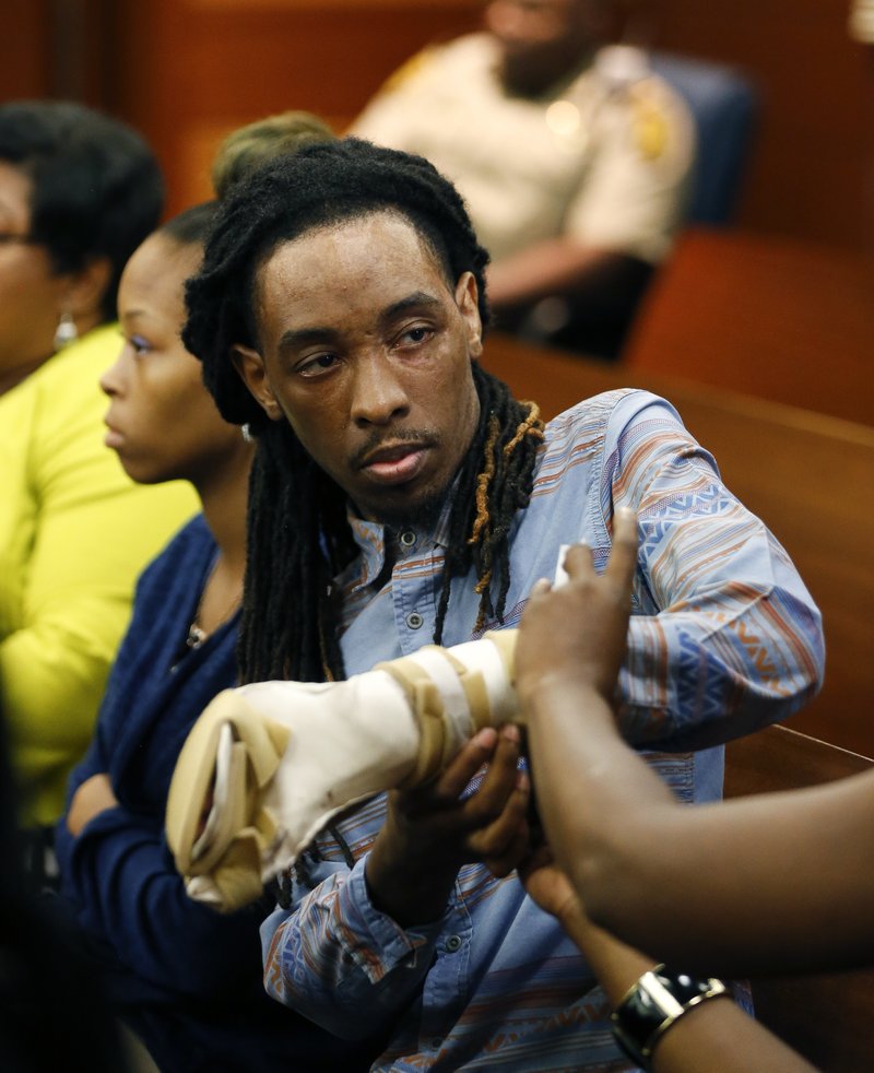 FILE - In this Aug. 24, 2016 file photo, burn victim Anthony Gooden gets help with his injured hand during a break in the trial for Martin Blackwell in Atlanta. Blackwell, who was convicted of throwing scalding water on a Gooden and his boyfriend while they slept, told one of them to &#x201c;get out of my house with all that gay,&#x201d; a victim testified, but he couldn&#x2019;t be charged with a hate crime because the state has no such law. Georgia is one of only four states - along with South Carolina, Wyoming and Arkansas - without an official hate crimes law.  (AP Photo/John Bazemore, File)