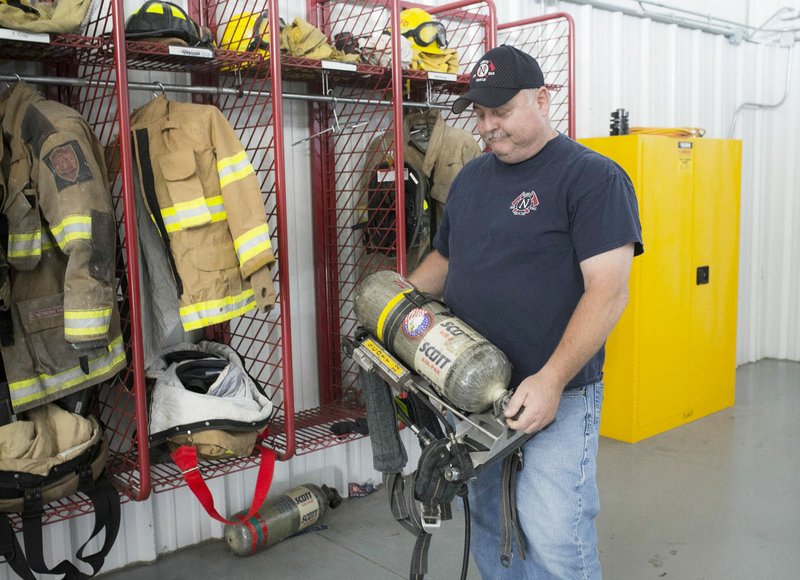 NWA Democrat-Gazette/CHARLIE KAIJO Fire Chief Rob Taylor holds a self contained breathing apparatus that's past it's effective date, Friday, May 24, 2019 at the NEBCO Fire Station No. 1 in Garfield. 

The Northeast Benton County Volunteer Fire Department will hold a special election to increase fire dues on July 9. It will be the first increase of any kind in 20 years for the department, Chief Rob Taylor said. The rate increase would help the district hire two part-time fire employees who would be on-site 24 hours a day, he said. Also lots of old gear will be replaced.

&quot;Materials break down, get worn out, doesn&#xe2;&#x20ac;&#x2122;t fit properly,&quot; Fire Chief Rob Taylor said of the team's fire gear, most of which is past its replacement date. &quot;Cancer is one of the leading causes of death to firefighters and it ties down to the gear we wear. It gets saturated with hydrocarbons from the fires.&quot;

Fire fighter uniforms are rated to last five years before they are no longer suitable to protect the firefighter. 