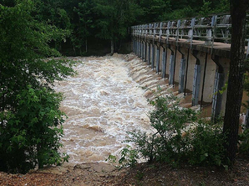 Water roars past the spillway at Lake Conway in Faulkner County on Monday. Authorities issued a flood warning for neighborhoods around the lake. 