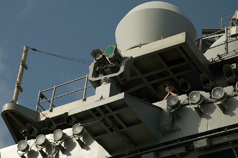 A sailor stands watch Monday on the USS Abraham Lincoln in the Arabian Sea. 