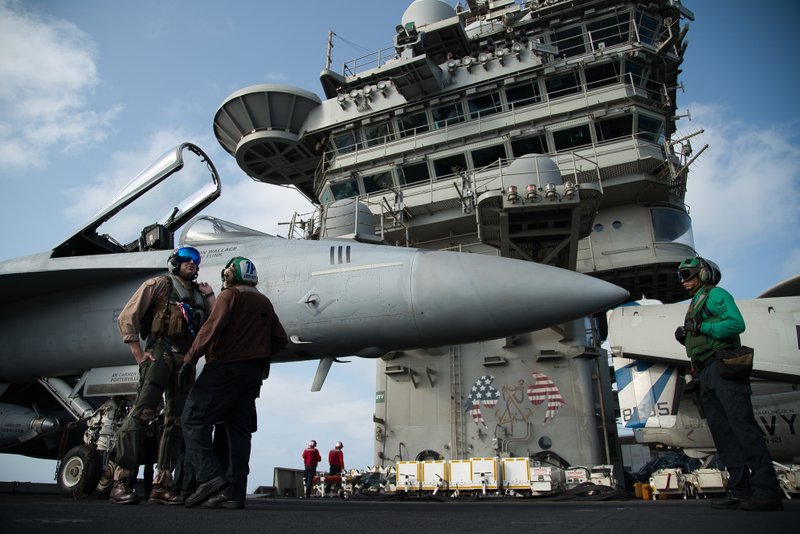 The Associated Press AIRCRAFT CARRIER: A pilot speaks to a crew member by an F/A-18 fighter jet on the deck of the USS Abraham Lincoln aircraft carrier in the Arabian Sea on Monday. The U.S. aircraft carrier the White House ordered to the Mideast over a perceived threat from Iran remains outside of the Persian Gulf amid efforts to de-escalate tensions between Tehran and Washington. story.lead_photo.caption