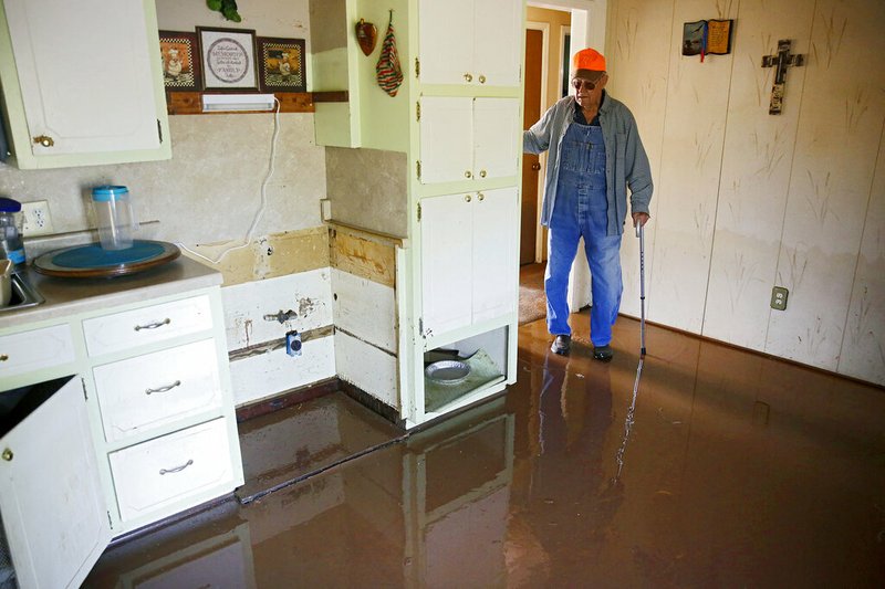 In this Thursday, May 30, 2019 photo, Eugene Bowers looks at the kitchen in his flooded home in the Town and Country neighborhood west of Sand Springs, Okla. (Mike Simons/Tulsa World via AP)