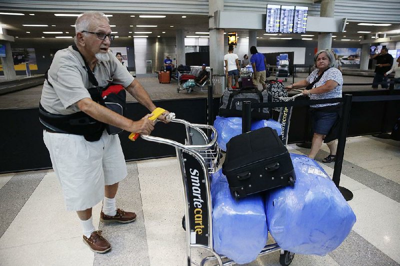 People wait Tuesday for their luggage to be checked in before their flight to Cuba at the Fort Lauderdale-Hollywood International Airport in Florida. 