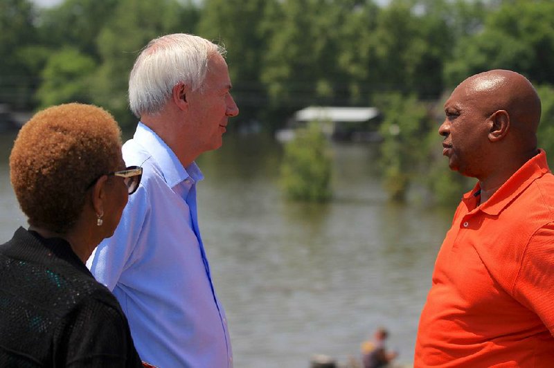 Gov. Asa Hutchinson views the flooding Tuesday in Jefferson County along with Pine Bluff Mayor Shirley Washington and Jefferson County Judge Gerald Robinson. Hutchinson said Jefferson County was probably the hardest hit area in the state “as far as one concentration of homes.” 