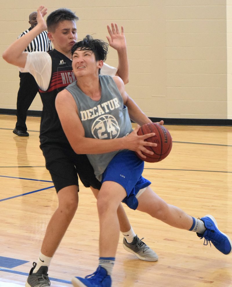 Westside Eagle Observer/MIKE ECKELS Decatur's Kevin Garcia drives toward the basket as a Highlander player attempts to block during the Decatur-Eureka Springs senior boys' basketball contest at the Decatur Middle School gym May 30. Both teams, along with Gentry and Colcord, were in Decatur participating in the 2019 Decatur Summer League.