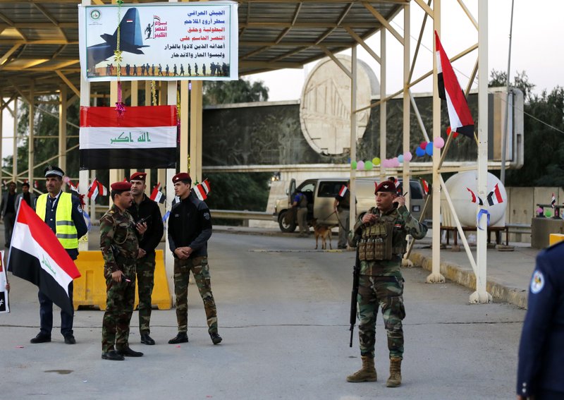 In this Dec. 10, 2018 file photo, Iraqi security forces stand guard as they check motorists entering the Green Zone, in Baghdad, Iraq. (AP Photo/Karim Kadim, File)