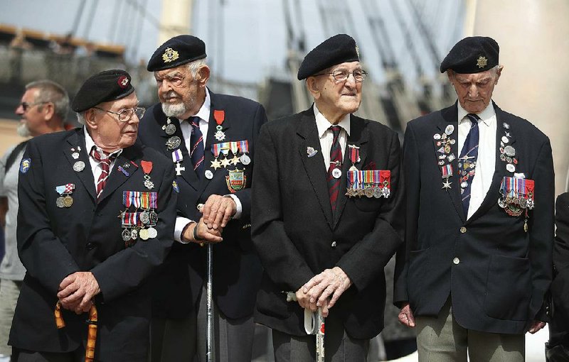 Veterans of the D-Day invasion gather Wednesday at a commemoration event at the Historical Dockyard in Portsmouth, England. Ten veterans of the battle took the stage as the crowd rose in applause. 