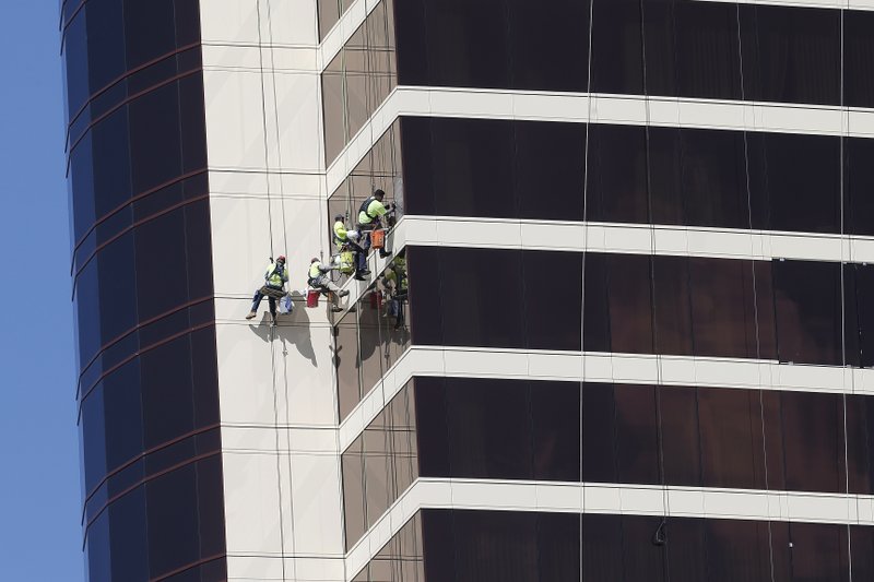 In this May 22, 2019, file photo window washers work on Encore Boston Harbor in Everett, Mass. (AP Photo/Michael Dwyer, File)