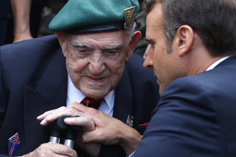 French President Emmanuel Macron, right, talks to French war veteran Leon Gautier, a member of the Kieffer commando, during a ceremony to pay homage to the Kieffer commando, Thursday, June 6, 2019 in Colleville-Montgomery, Normandy. The Kieffer commando, an elite French unit, was among the first waves of Allied troops to storm the heavily defended beaches of Nazi-occupied northern France, beginning the liberation of western Europe. (AP Photo/Francois Mori, Pool) story.lead_photo.caption