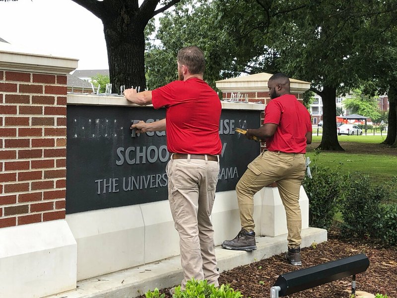 University of Alabama employees remove the name of Hugh F. Culverhouse Jr. off the School of Law sign in Tuscaloosa, Ala., Friday, June 7, 2019. The University of Alabama board of trustees voted Friday to give back a $26.5 million donation to a philanthropist Hugh F. Culverhouse Jr., who recently called on students to boycott the school over the state's new abortion ban. (AP Photo/Blake Paterson)