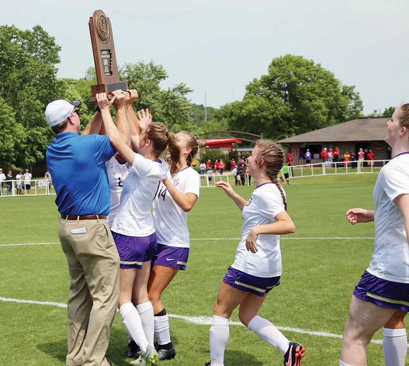 Members of the Central Arkansas Christian girls soccer team accept the Class 3A state-championship trophy from Joey Walters, deputy executive director for the Arkansas Activities Association.