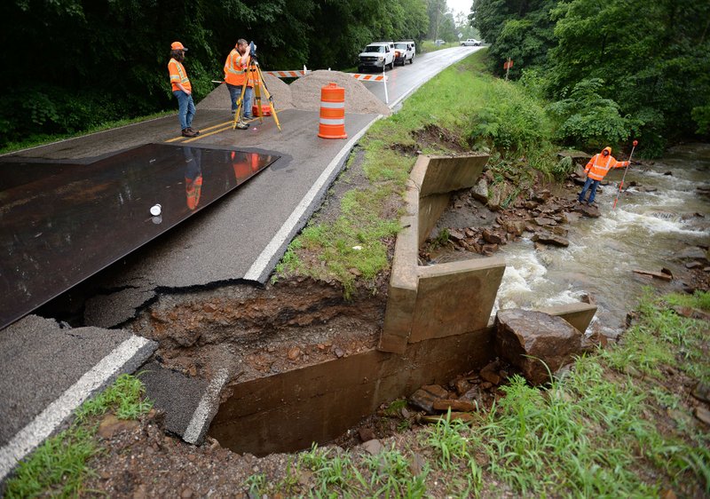 Engineers and workers with the Arkansas Department of Transportation survey Friday, June 7, 2019, the area around a bridge on Arkansas 265 in Hogeye after the creek it spans washed away the roadbed during heavy rains Thursday evening. The highway is closed south of the Arkansas 156 intersection.