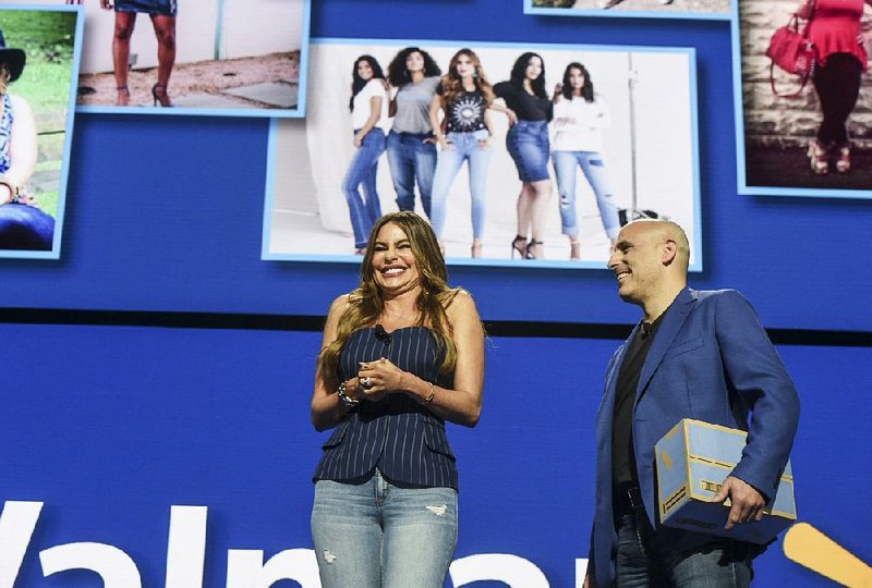Sofia Vergara of the Modern Family television series and Marc Lore, chief executive of Walmart e-commerce in the United States, show off the line of jeans Vergara designed for the company at the Walmart celebration Friday in Bud Walton Arena in Fayetteville.