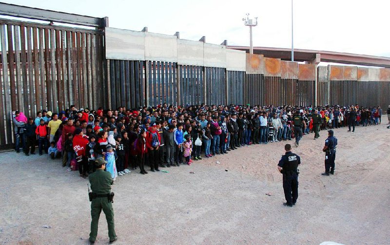 U.S. Customs and Border Protection officials detain people in late May at the border in El Paso, Texas. The growing influx has caused officials to open a facility to hold up to 1,600 migrant teens in Carrizo Springs, Texas, and is looking at sites to hold another 1,400 young migrants. 