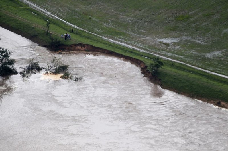 People observe the deteriorating Arkansas River levee in the Lollie Bottoms area near Conway on Friday, June 7, 2019.