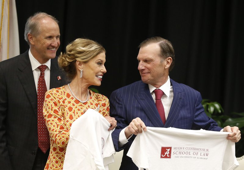 In this Sept. 20, 2018, photo, Hugh F. Culverhouse Jr., right, and wife, Eliza, in Tuscaloosa, Ala., show off T-shirts from the the University of Alabama law school, which now bears his name. The university appears poised to reject a $26.5 million pledge by Culverhouse, who recently called on students to boycott the university over the state&#x2019;s new abortion ban. (Gary Cosby Jr./The Tuscaloosa News via AP)