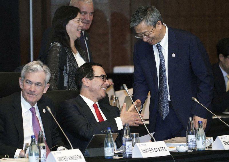 Treasury Secretary Steve Mnuchin visits with Yi Gang, head of China’s central bank, before the start of a meeting of Group of 20 financial leaders Saturday in Fukuoka, Japan.