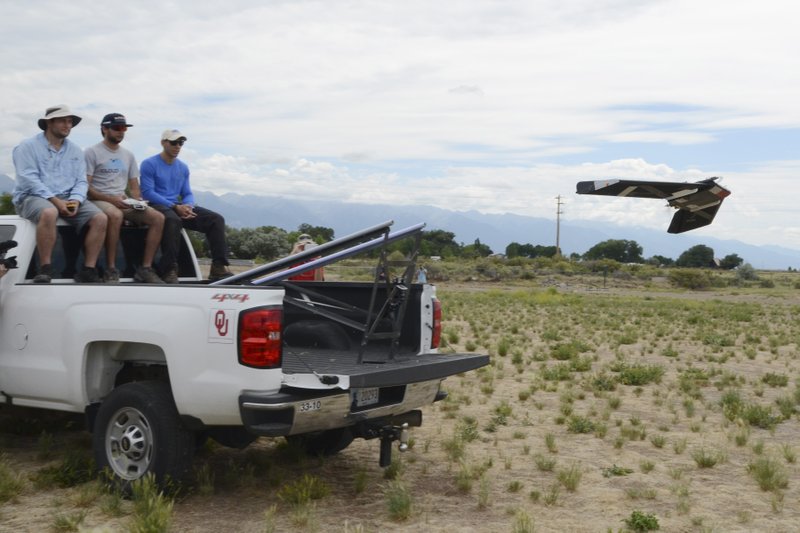 In this July 2018 photo provided by Tyler Bell of the University of Oklahoma Center for Autonomous Sensing and Sampling, Bill Doyle, Tony Segales and Gus Azevedo launch a drone in Moffat, Colo. Researchers at the University of Oklahoma and Oklahoma State University are jointly developing drone technology to more accurately forecast the weather. (Tyler Bell via AP)