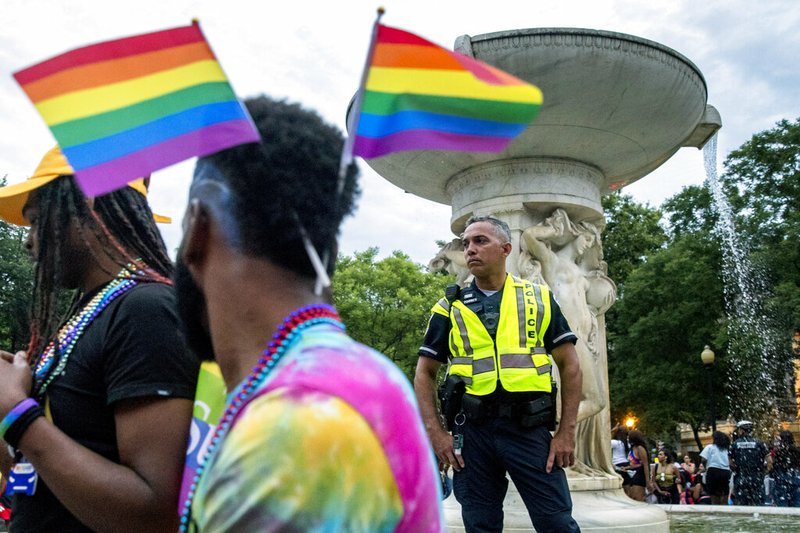 A police officer watches the crowd at the conclusion of the Capitol Pride Parade at Dupont Circle in Washington, Saturday, June 8, 2019.