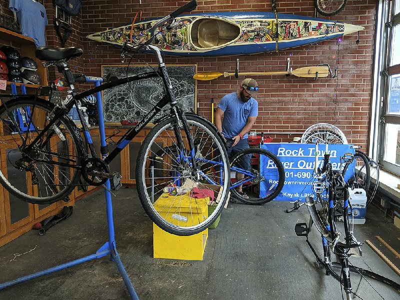 Samuel Ellis inspects a bike Thursday at Rock Town River Outfitters in Little Rock.