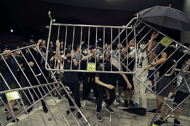 Demonstrators outside the government headquarters in Hong Kong break through barriers early today as they protest the extradition bill. 
