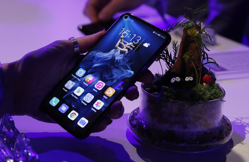 FILE - In this Tuesday, May 21, 2019 file photo, a member of the media tries out new Huawei Honor 20 series of phones following their global launch in London. Facebook has stopped letting its apps come pre-installed on smartphones sold by Huawei to comply with U.S. restrictions, dealing a fresh blow to the Chinese tech giant. The social network said Friday, June 7 it suspended providing software for Huawei to put on its devices while it reviews recently introduced U.S. sanctions. (AP Photo/Alastair Grant, file) story.lead_photo.caption