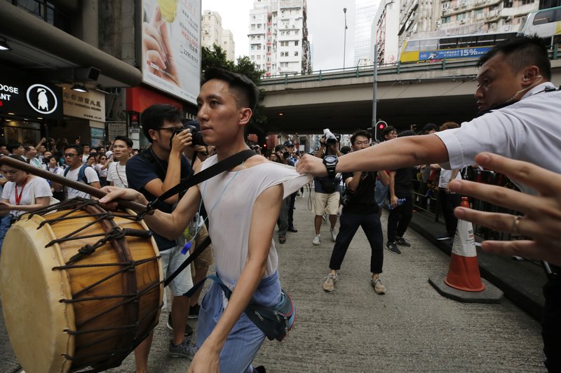 A protester is grabbed by a policeman as he crosses the police line during a rally in Hong Kong on Sunday, June 9, 2019. A sea of protesters marched through central Hong Kong in a major demonstration against government-sponsored legislation that would allow people to be extradited to mainland China to face charges. (AP Photo/Kin Cheung)