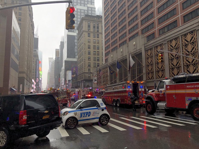 Bloomberg/KATRINA LEWIS NYPD and FDNY in Midtown Manhattan on Monday after a helicopter crashed into a building.