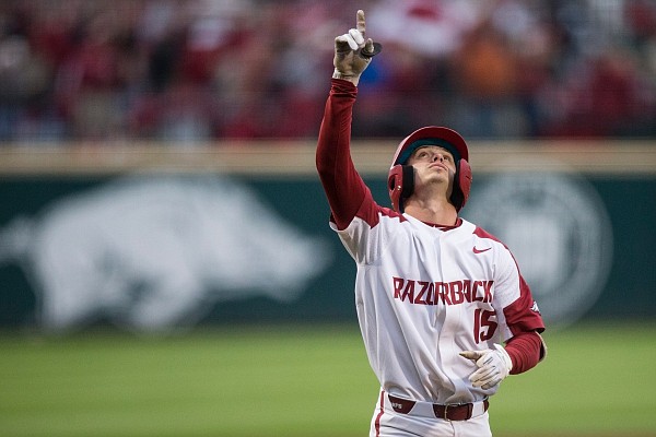 Casey Martin, Arkansas shortstop, points to the sky after hitting a home run at Baum-Walker Stadium in Fayetteville.
