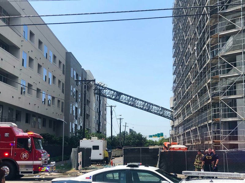 This photo taken and provided by Michael Santana shows a construction crane toppling on an apartment building as it was buffeted by high winds during a storm in Dallas, Texas, Sunday, June 9, 2019. (Michael Santana via AP)