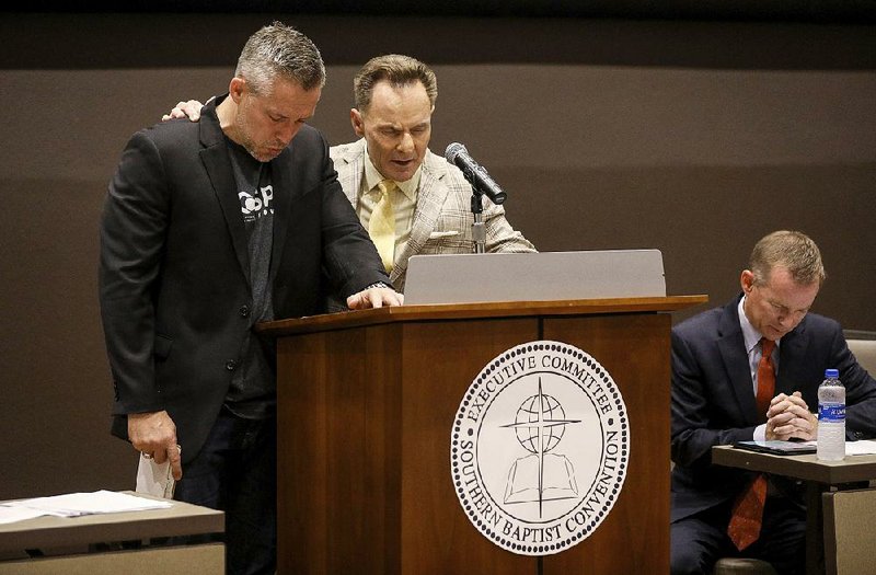 J.D. Greear (left), president of the Southern Baptist Convention, and Ronnie Floyd, president and CEO of the SBC Executive Committee, pray during a meeting Monday at the group’s conference in Birmingham, Ala. 