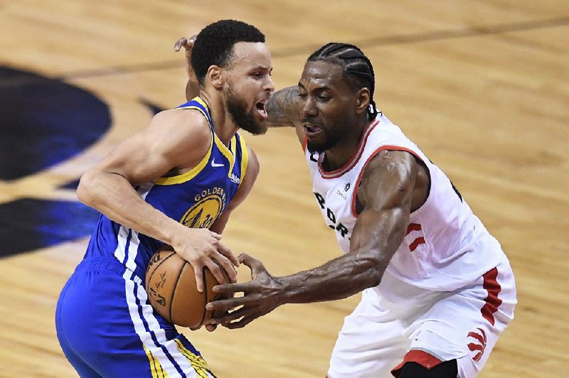 Toronto Raptors forward Kawhi Leonard (right) defends against Golden State Warriors guard Stephen Curry during the first half of Game 5 of the NBA Finals on Monday in Toronto. Curry finished with 31 points, 8 rebounds and 7 assists as the Warriors won 106-105 to stave off elimination. story.lead_photo.caption