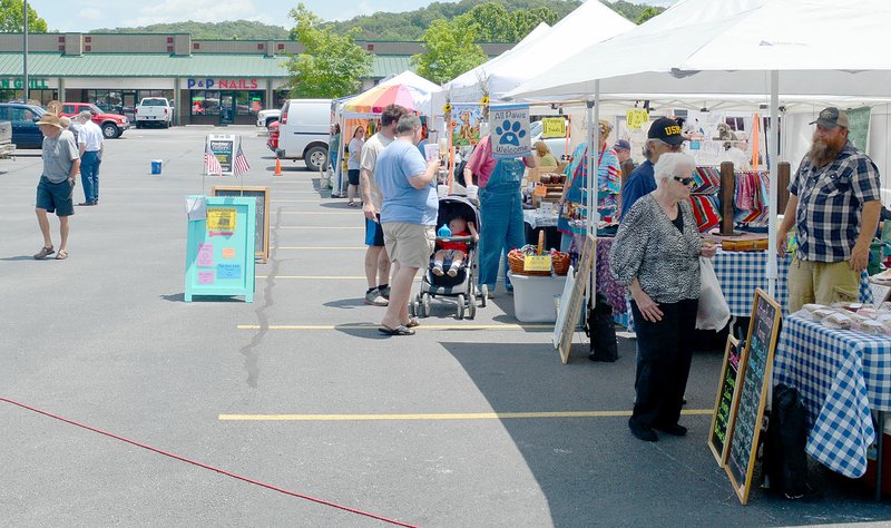 Keith Bryant/The Weekly Vista Shoppers make their way through the Bella Vista Farmers Market on a hot Sunday afternoon. The market is open Sundays from 9 a.m. to 2 p.m.