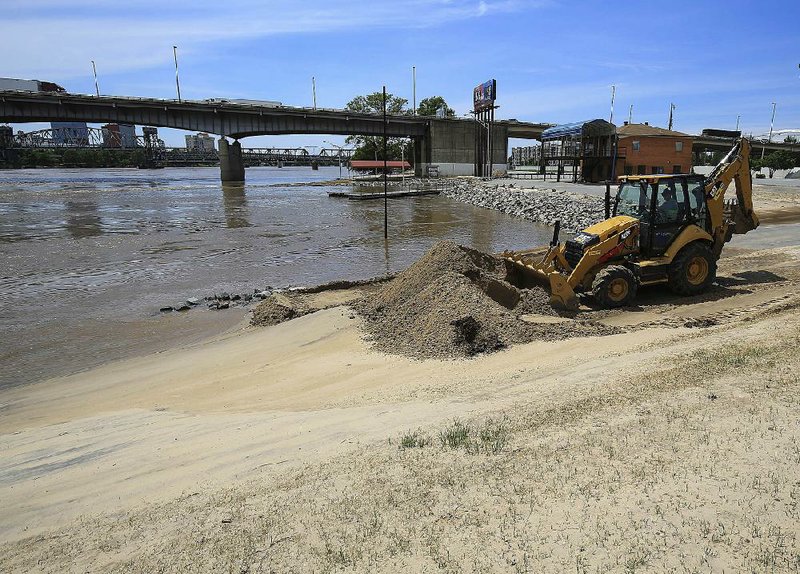 North Little Rock city workers clear sand from a parking lot Tuesday near North River Landing on the edge of the Arkansas River. 