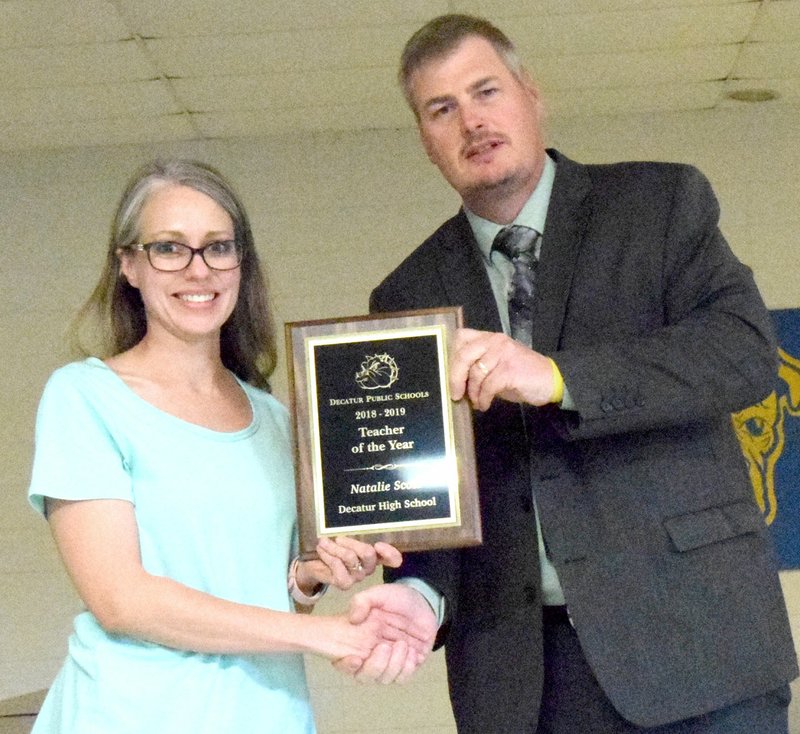 Westside Eagle Observer/MIKE ECKELS Natalie Scott receives the Decatur High School Teacher of the Year Award from Steve Watkins during the May 21 teacher gathering in the cafeteria at the high school.