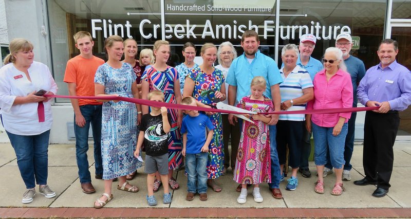 Westside Eagle Observer/RANDY MOLL Rustin and Gwyn Unruh, with the help of children Collin and Maddison, cut the ribbon on their new furniture store in Gentry, Flint Creek Amish Furniture, on Thursday (June 6, 2019). Also on hand for the occasion were Gentry Chamber of Commerce director Janie Parks, Clay Arnold, Shana Arnold, Amber Koehn, Zoey Koehn, Ethan Koehn, Karys Arnold, Susan Zeiset, Maxine Foster, Janice Arnold, Kenneth Wise, Linda Byrnes, Sam Byrnes and Mayor Kevin Johnston.