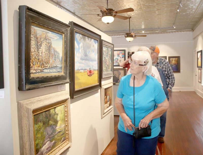 LYNN KUTTER ENTERPRISE-LEADER Marjorie Johnson of Lincoln looks at original paintings in the Arkansas Territory Collection Exhibition, on display at The Museum Gallery at Historic Cane Hill. The exhibit runs through June 30. Johnson was with a group from Lincoln Senior Center on Friday morning.