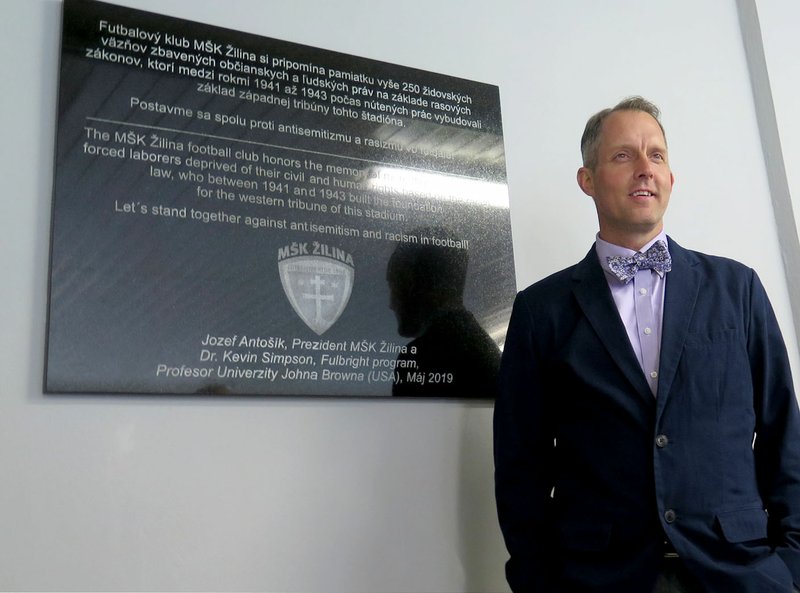Photos submitted Kevin Simpson, psychology professor at John Brown University, stood by the memorial plaque installed in honor of the more than 250 Jewish forced laborers who helped build one of the grandstands at a soccer stadium in Slovakia that is now home to one of the country's top teams -- M&#352;K &#381;ilina. The memorial was unveiled during a ceremony on May 15.