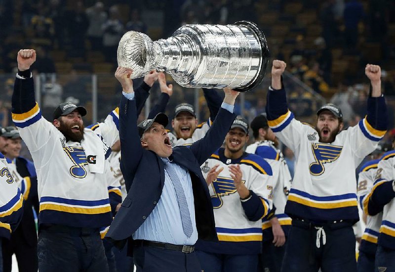 St. Louis Coach Craig Berube hoists the Stanley Cup after the Blues clinched their first NHL title with a 4-1 victory over the Boston Bruins in Game 7 of the Stanley Cup Final on Wednesday night in Boston. 