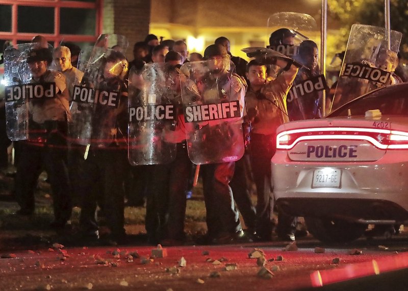 Shelby County Sheriff's deputies brace against the crowd as protesters take to the streets of the Frayser community in anger against the shooting a youth identified by family members as Brandon Webber by U.S. Marshals earlier in the evening, Wednesday, June 12, 2019, in Memphis, Tenn. (Jim Weber/Daily Memphian via AP)
