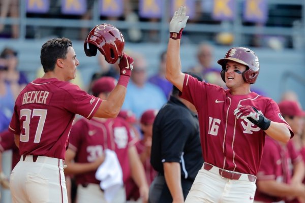 Florida State's Mike Salvatore (16) and Tim Becker (37) celebrate after they scored on Reese Albert's tying three-run home run against LSU in the seventh inning of Game 1 of the NCAA college baseball super regional tournament in Baton Rouge, La., Saturday, June 8, 2019. (AP Photo/Gerald Herbert)