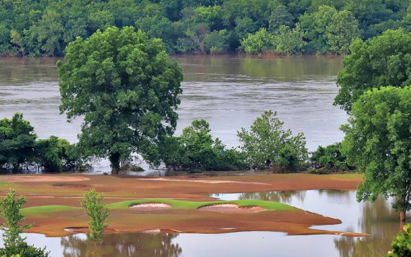 FILE — The Arkansas River flows in the background Saturday as its floodwaters cover sections of Little Rock’s Rebsamen Golf Course. 