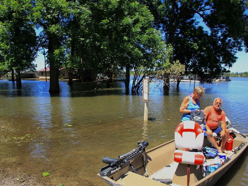 Arkansas Democrat-Gazette/Dale Ellis - Greg and Lanette James get ready to disembark from their boat after taking a look around the Riverside Drive neighborhood in Pine Bluff. Although their home did not take on any water, it was close, they said. "When we were told the crest was going to 51 feet, we started getting nervous," Greg James said. We got lucky. A lot of our neighbors didn't."