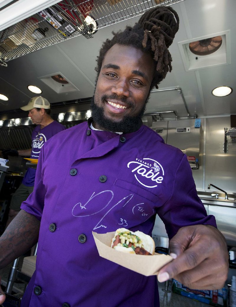 Minnesota Vikings running back Dalvin Cook serves food from Vikings Table, the team’s food truck that will serve  free healthy meals to children in need this summer. 
