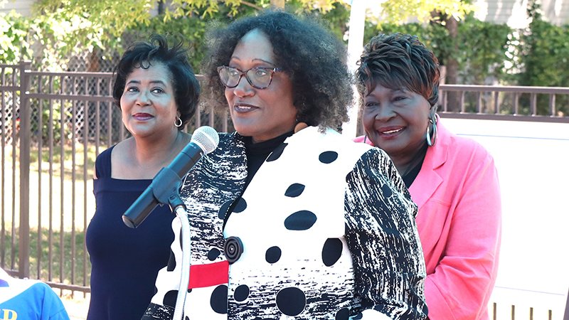 The Sentinel-Record/Richard Rasmussen A DAUGHTER'S PRIDE: Donnellda Rice, center, the daughter of the Rev. James Donald Rice, speaks Thursday during a dedication ceremony for a pocket park named for her father at 511 Pleasant St. as Jean Lacefield, left, president of the Gateway Community Association, and City Director Elaine Jones, District 2, look on.