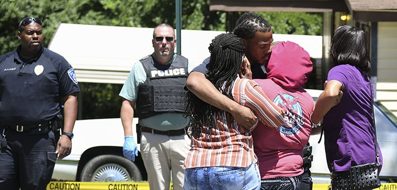 The Sentinel-Record/Grace Brown CRIME SCENE: Family members embrace, above, in the 200 block of Portland Street where one man was killed Thursday afternoon.